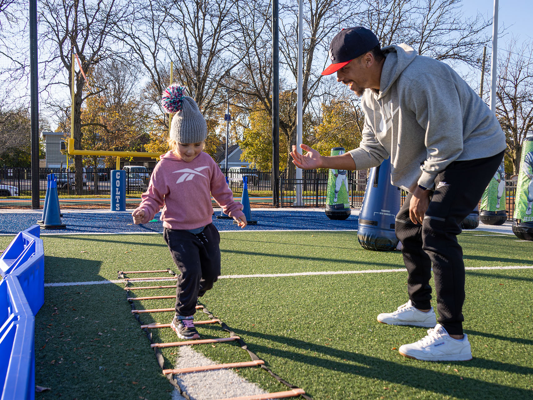 Child running drills on football field.