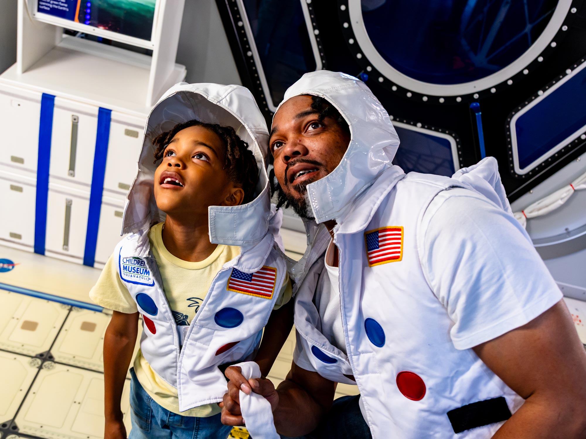 Grown-up and child wearing astronaut costumes.
