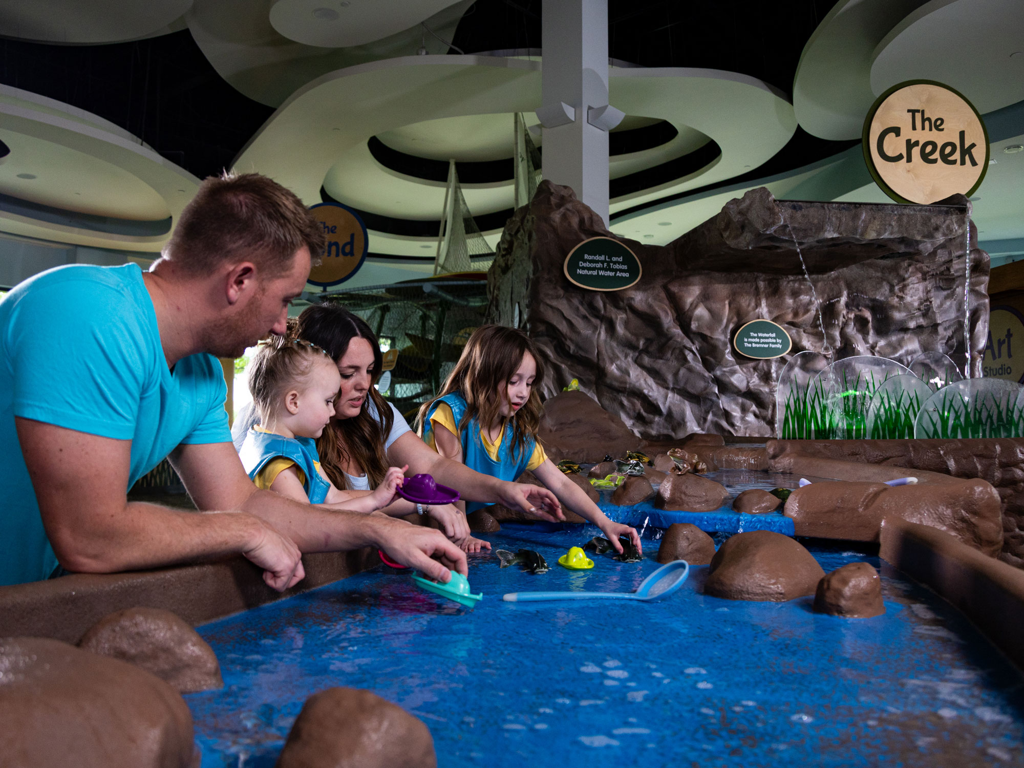 Family playing in water table.