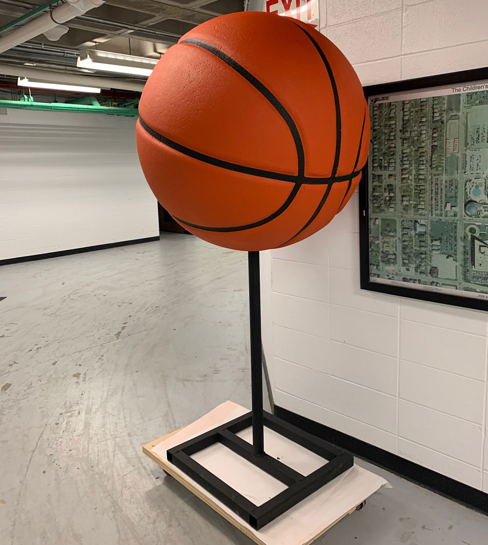 Behind the scenes photo of completed March Madness dino basketball at The Children's Museum of Indianapolis