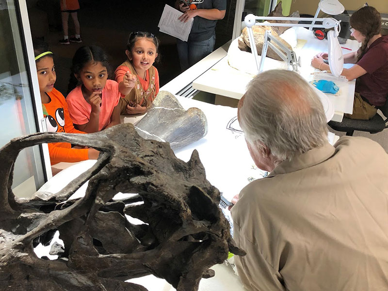 Children examining bones in the Jurassic Paleo Prep Lab window at The Children's Museum of Indianapolis