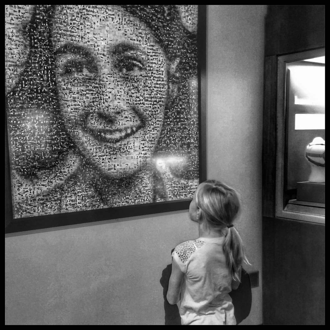 Girl looking at photo mosaic of Anne Frank on display in The Power of Children: Making a Difference at The Children's Museum of Indianapolis