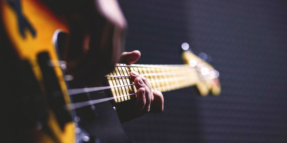 Close up of hands playing a guitar.