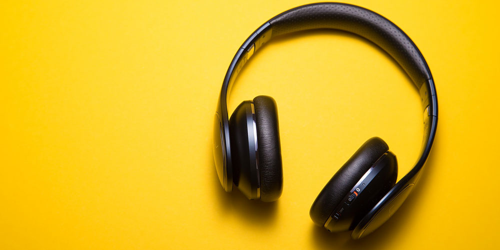 Black headphones against a yellow background