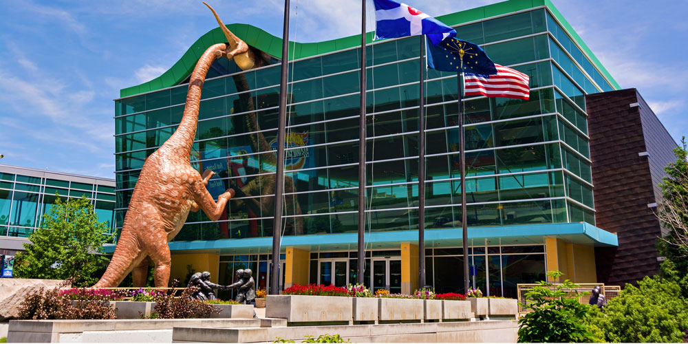 Sculpture of adult and child Brachiosaurs climbing into The Children's Museum of Indianapolis