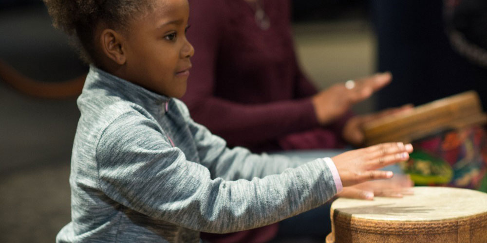 Girl playing the drums at Rhythm! Discovery Center