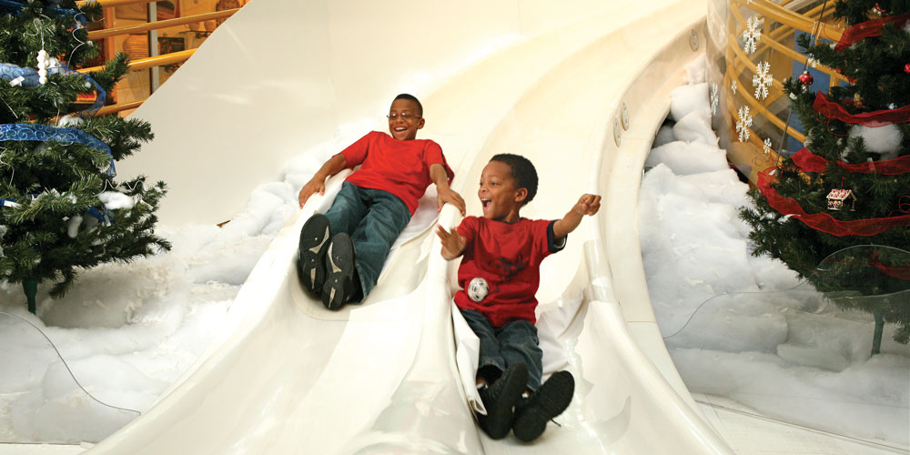 Two children sliding down the Yule Slide.
