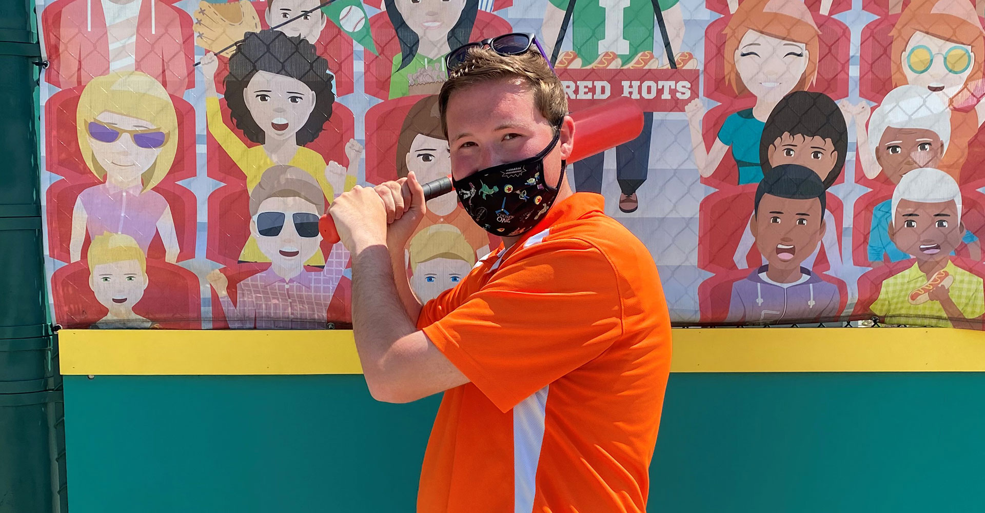 Riley Children's Health Sports Legends Experience coach Brian holding a baseball bat in Wiese Field at The Children's Museum of Indianapolis