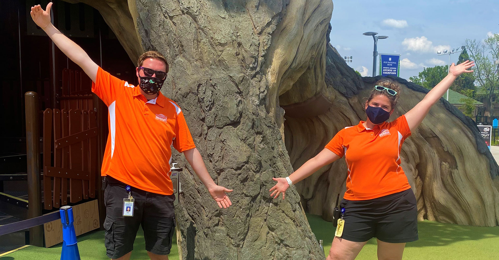 Riley Children's Health Sports Legends Experience coaches Brian and Elizabeth in front of the Tree of Sports at The Children's Museum of Indianapolis