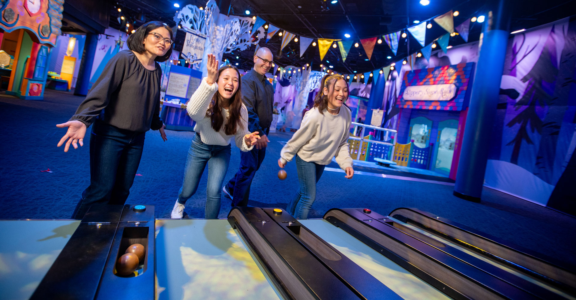 Grown-ups playing Skee-Ball.