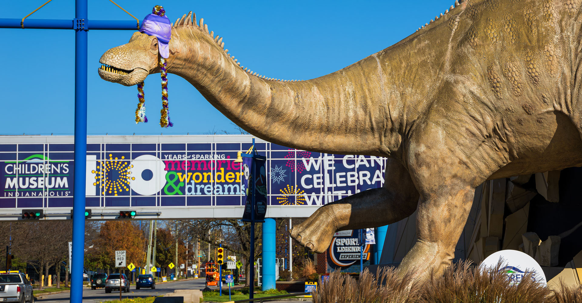 Sculpture of dinosaurs bursting out of the museum with a giant purple microphone and wearing Taylor Swift-inspired friendship bracelets.