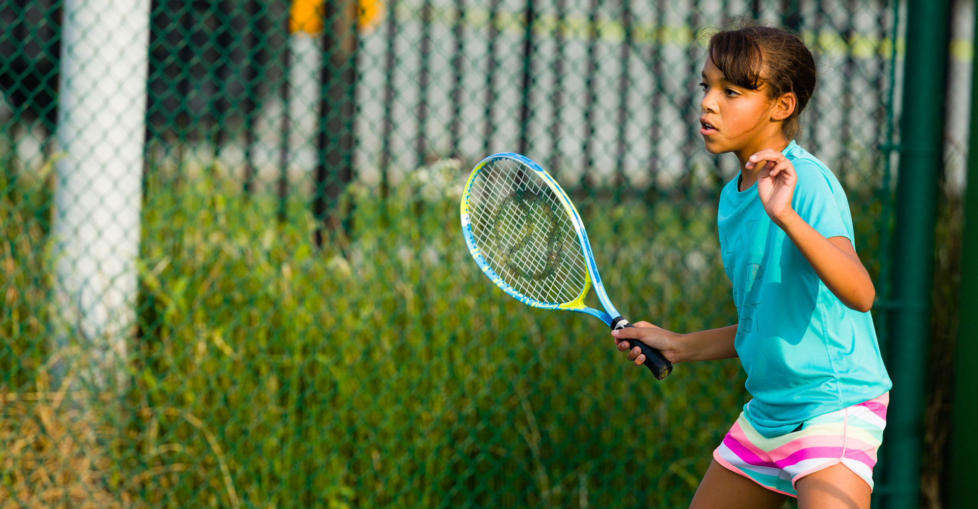 Child holding a tennis racquet. 