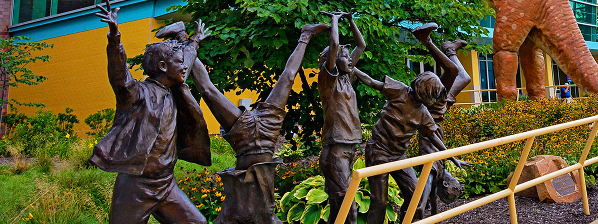 Bronze statue of five children playing outside of The Children's Museum