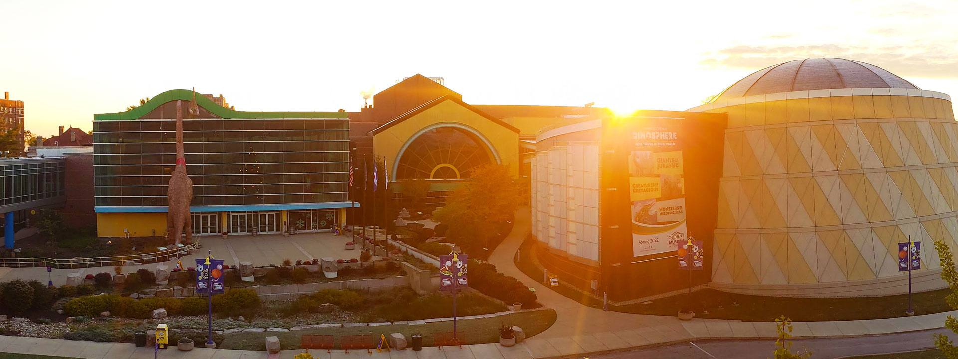 Exterior of The Children's Museum of Indianapolis with the sun rising in the background.