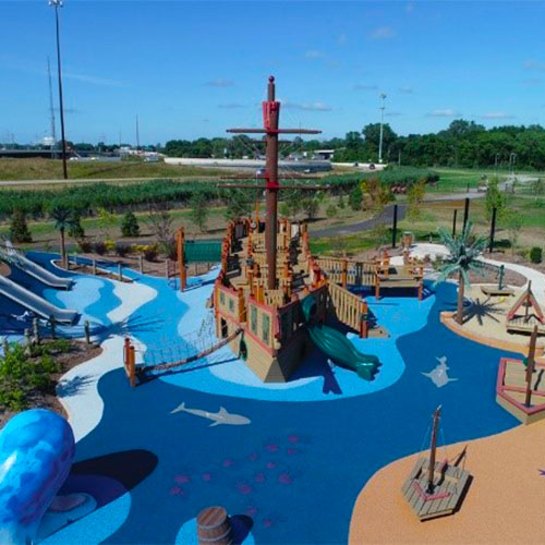 Play area with a pirate ship surrounded by blue landscaping that looks like water at Access Pass cultural attraction Bellaboo's Imagination Garden