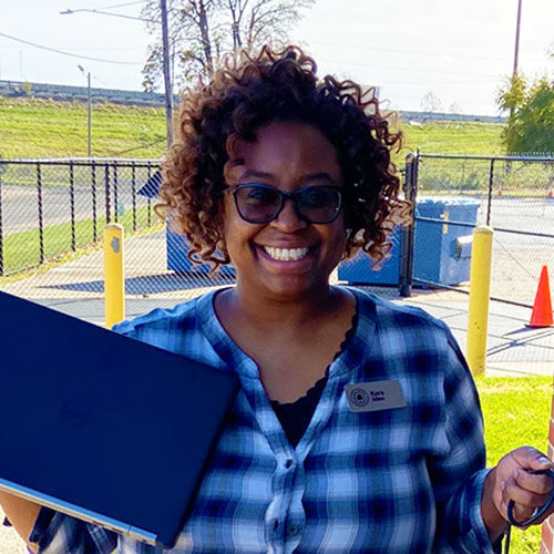 Woman holding laptop she won in a raffle at an Old National Bank Financial Empowerment Workshop