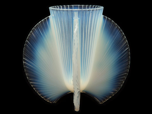 Illuminated glass vase from the David Huchthausen Collection against a black background.