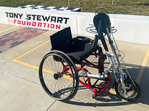 Wheelchair with the hand cycle attachment attached.