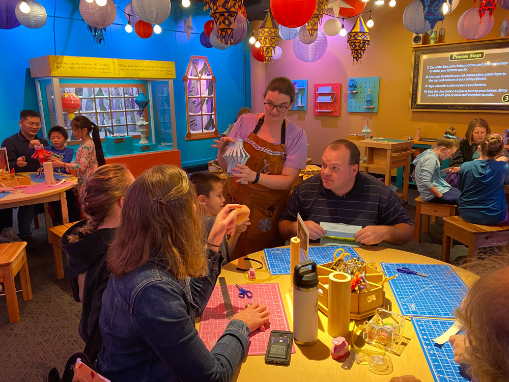 Staff and families making a lantern in Gerty's workshop