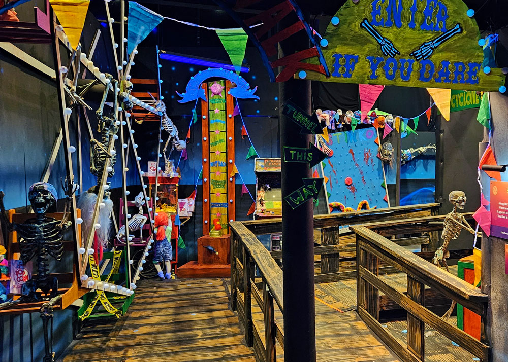 Skeletons playing carnival games and riding a Ferris wheel.