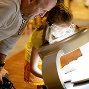 Adult and child looking through a magnifying glass